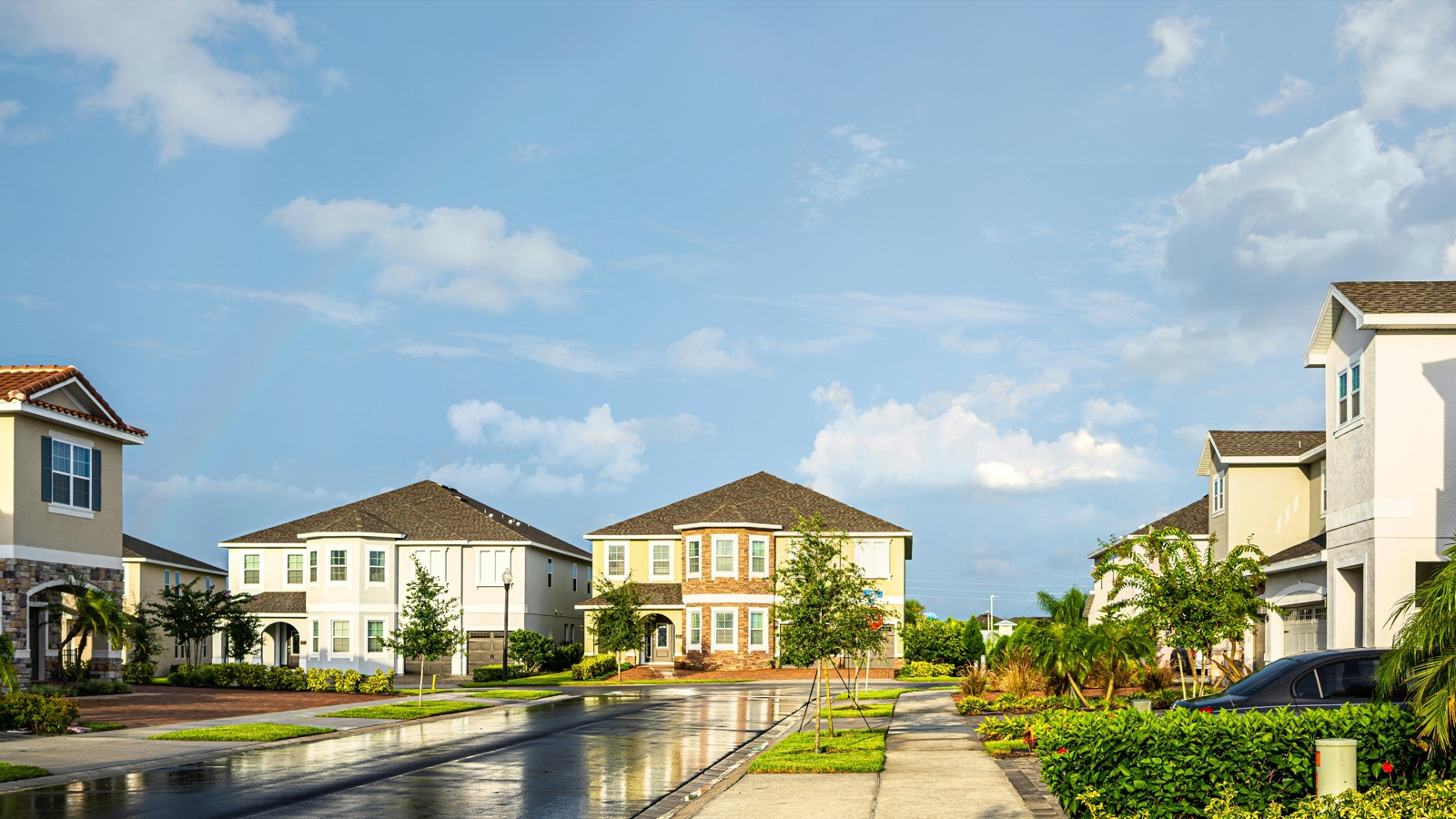 Two-story single-family homes on a South Florida residential street after rain