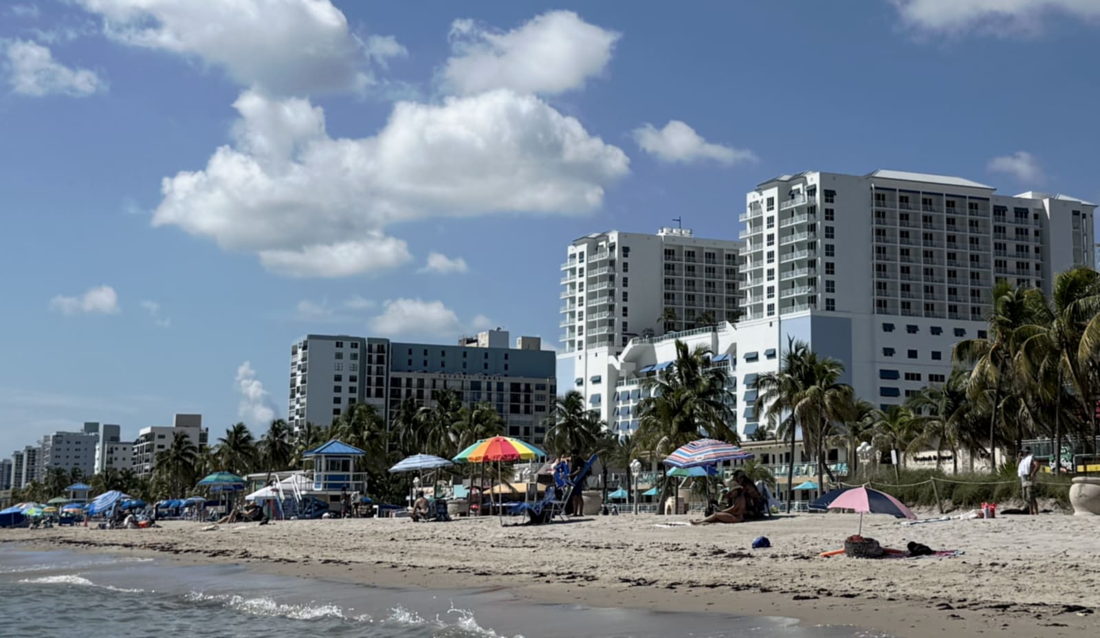 Hollywood Beach, Florida: mid-rise oceanfront condominium and hotel buildings lining the sand, with palms along the Broadwalk