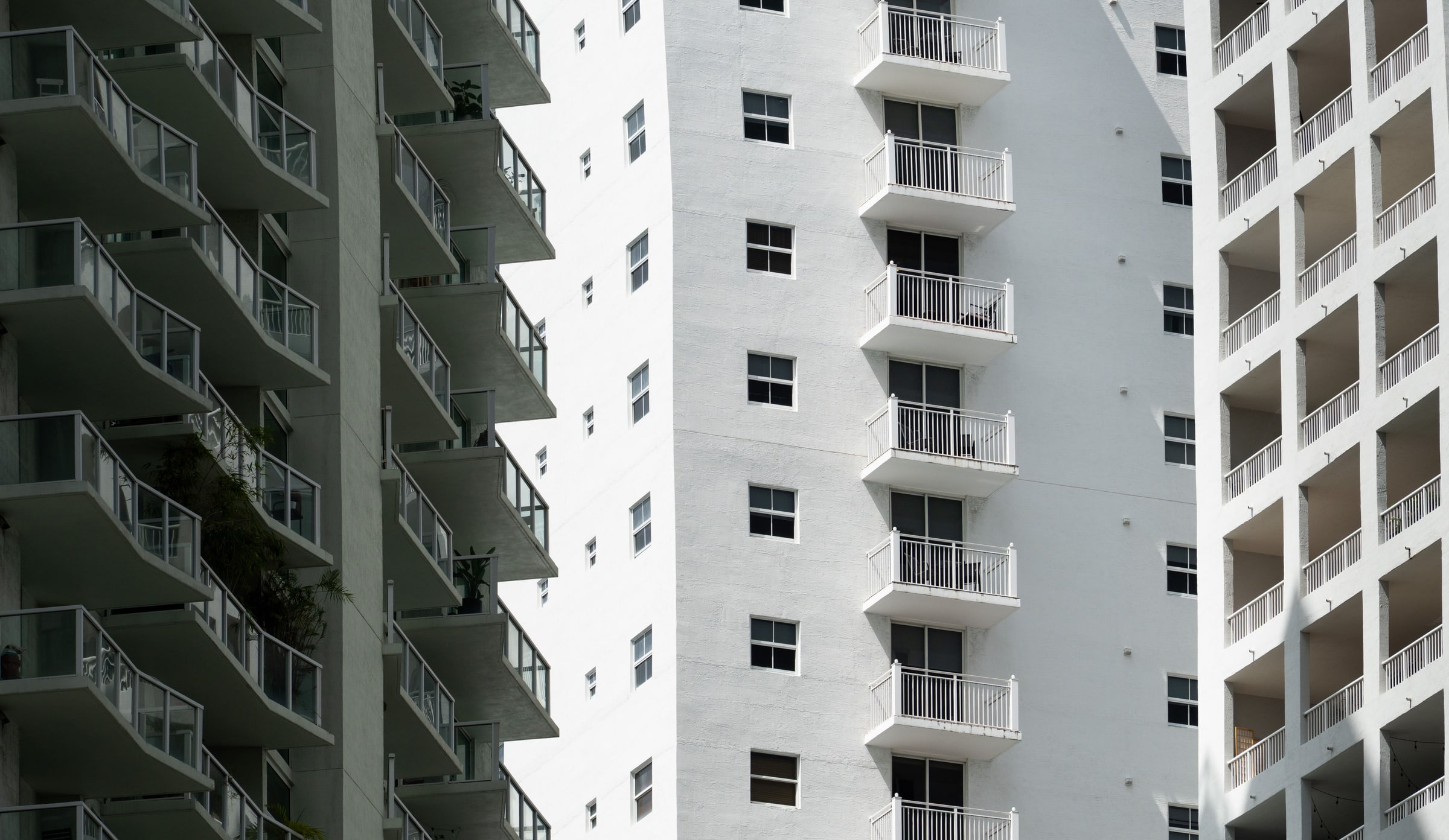 Stacked balconies across three adjacent modern high-rise residential buildings in Miami, Florida